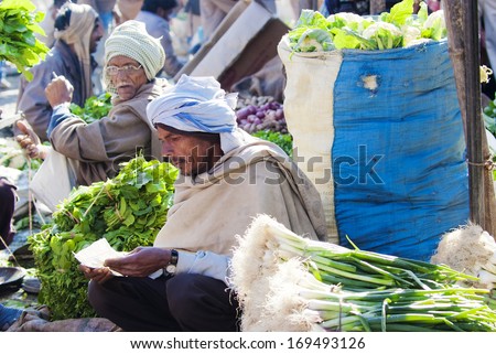 AGRA, INDIA - MAR 01: vendors wait for customers at a vegetable market on Mar 01, 2013 in Agra, India.  A variety of vegetables, fruits and other produce are available at Agra\'s morning markets.