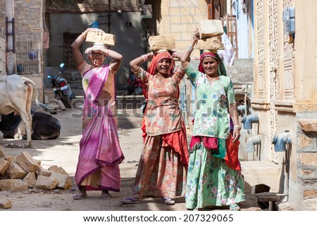 JAISALMER, INDIA - FEB 26: women carry a brick on their head on a construction site on Feb 26, 2013 in Jaisalmer, India. Construction is the third-largest employer of women in India
