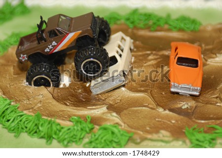 Macro of a birthday cake for a 5 year-old boy with toy \'big\' trucks