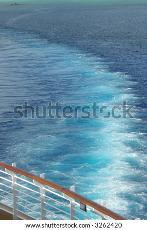 Wake from a cruise ship in the Bahama\'s bright aqua water.  This was taken from the upper deck with only water and the ship\'s rail visible.