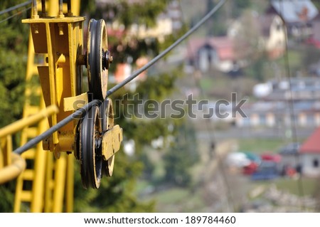 Detail of tow rope with wheels and yellow construction from cableway mechanism