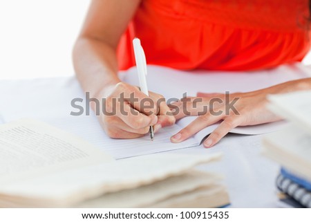 Close-up of a pen using by a student to do her homework against white background