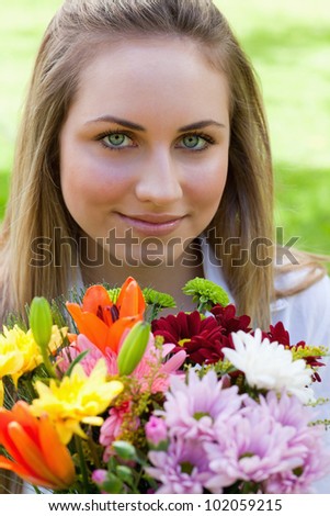 Young relaxed girl holding a wonderful bunch of flowers in the countryside