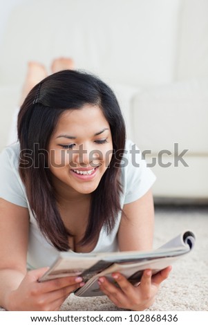 Woman smiles as she reads a magazine in a living room