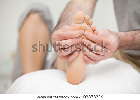 Sole of a foot being touched by a doctor in a room