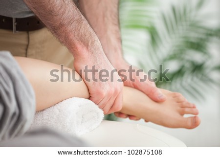 Close-up of a foot being massaged by a doctor in a room