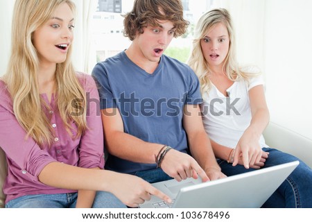 Three friends are shocked at what they have seen on the laptop screen