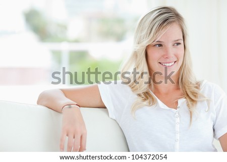 A smiling woman sitting on the couch as she looks to the side