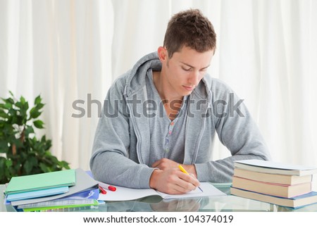Male student doing his homework in his house