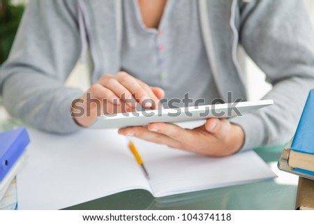 Close-up of a student using a touch pad while doing his homework