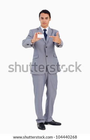 Good-looking man showing and pointing his business card against white background