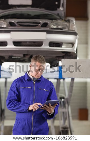 Mechanic touching a tablet computer in a garage