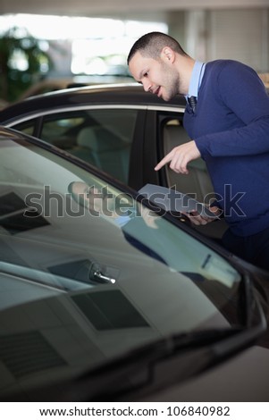 Man looking inside a car in a dealership