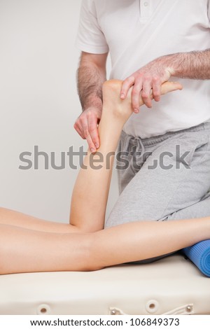 Podiatrist massaging the ankle of a woman in a room