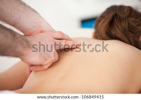 Doctor massaging his patient while using only two fingers in a room