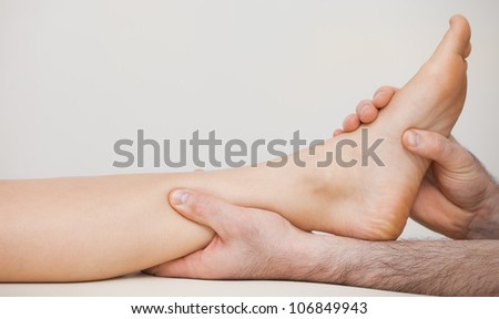 Chiropodist holding the ankle of a patient in his medical room