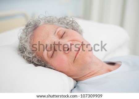 Patient sleeping on a medical bed in hospital ward