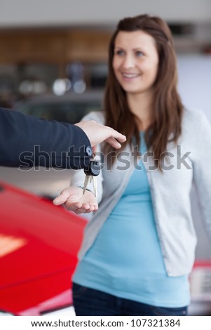 Brunette receiving car keys in his hand in a garage