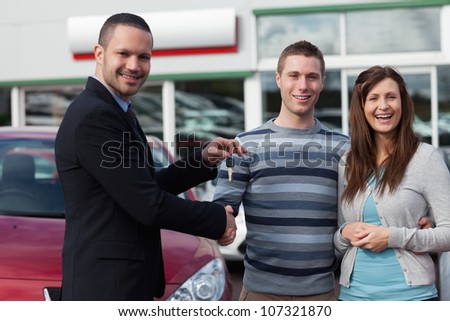 Salesman shaking hand of man in a dealership