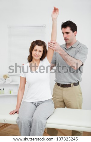 Peaceful woman keeping her arm up in a medical room