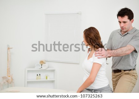 Brunette woman moving her upper body in a medical room