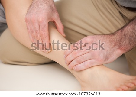 Physiotherapist massaging the shin bone indoors