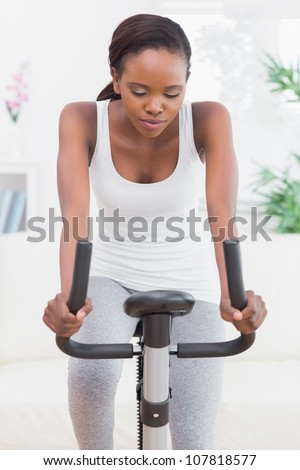 Woman doing exercise bike in a living room