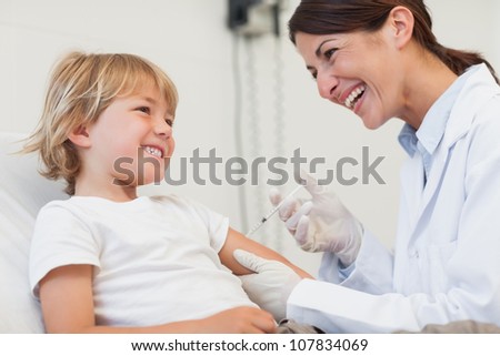 Child receiving an injection in examination room