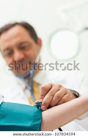 Doctor placing his stethoscope on the arm of his patient in an examination room