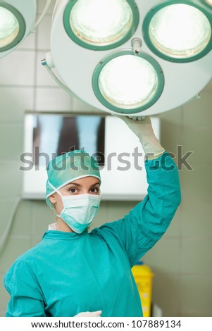 Surgeon holding a surgery light in a surgical room