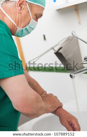 Surgeon washing his hands in a sink