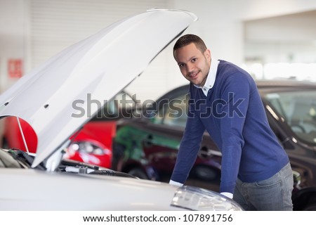 Man leaning over a car in a dealership