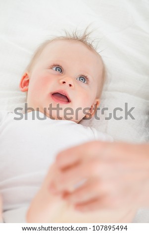 Happy baby lying on the back on a blanket
