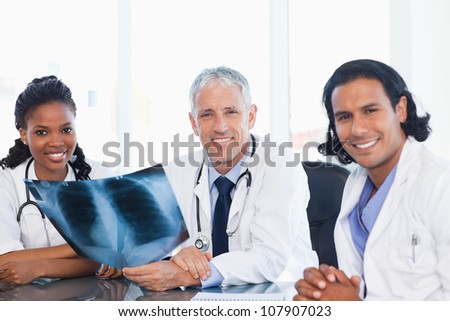 Confident medical team smiling while working hard with a patient\'s x-ray