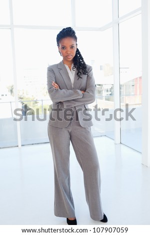 Young secretary seriously looking ahead and crossing her arms