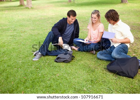 High angle-shot of three students in a park studying