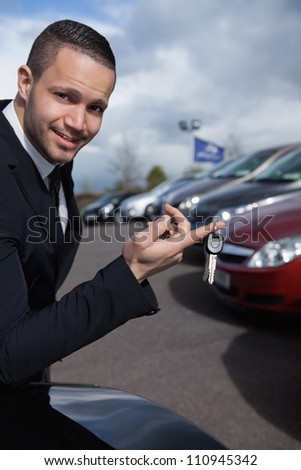 Man holding car keys with a finger outdoors