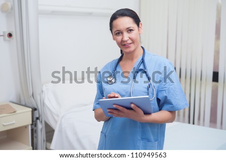 Nurse using a tablet pc in hospital ward