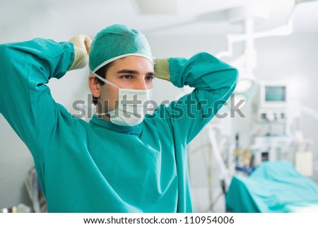 Surgeon attaching his mask in an operating theater