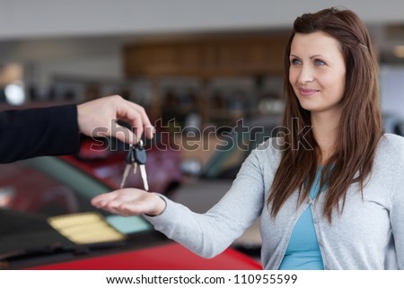 Woman receiving car keys in his hand in a garage
