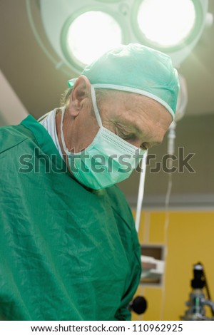 Surgeon under a surgical light in a surgical room