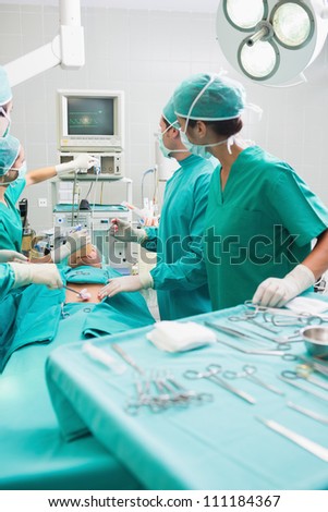Surgeons checking a monitor while operating in an operating theater