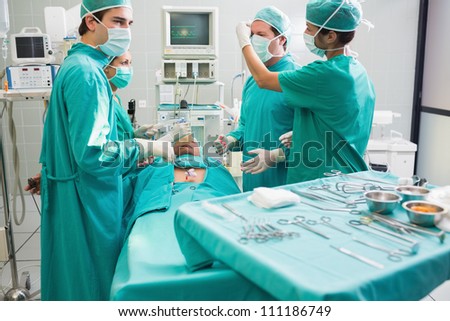 Surgeon operating an unconscious patient in an operating theater in a hospital