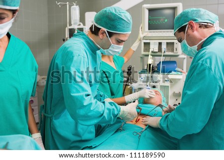 Surgeons operating with surgical tools in an operating theater