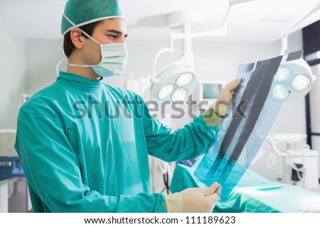 Surgeon standing while looking at a X-ray in an operating theater