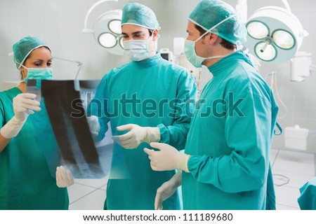 Surgeons operating with surgical tools in an operating theater