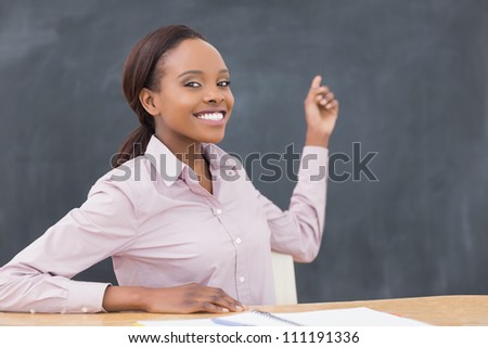 Black teacher showing the blackboard in a classroom