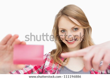 Woman holding a loyalty card while showing it against a white background