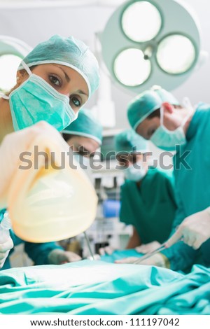 Focus on a nurse holding an anesthesia mask in an operating theater