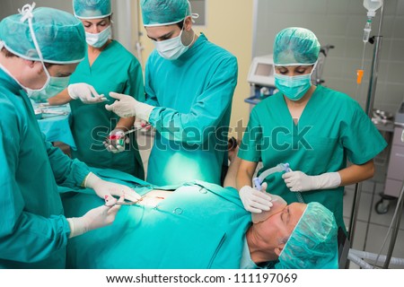 Nurse giving a surgical tool to a surgeon in an operating theater